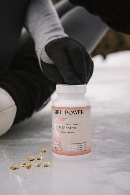 Bouteille HER SHINE Girl Power vitamine D3 pour femme avec capsules au sol – supplément immunité et santé osseuse